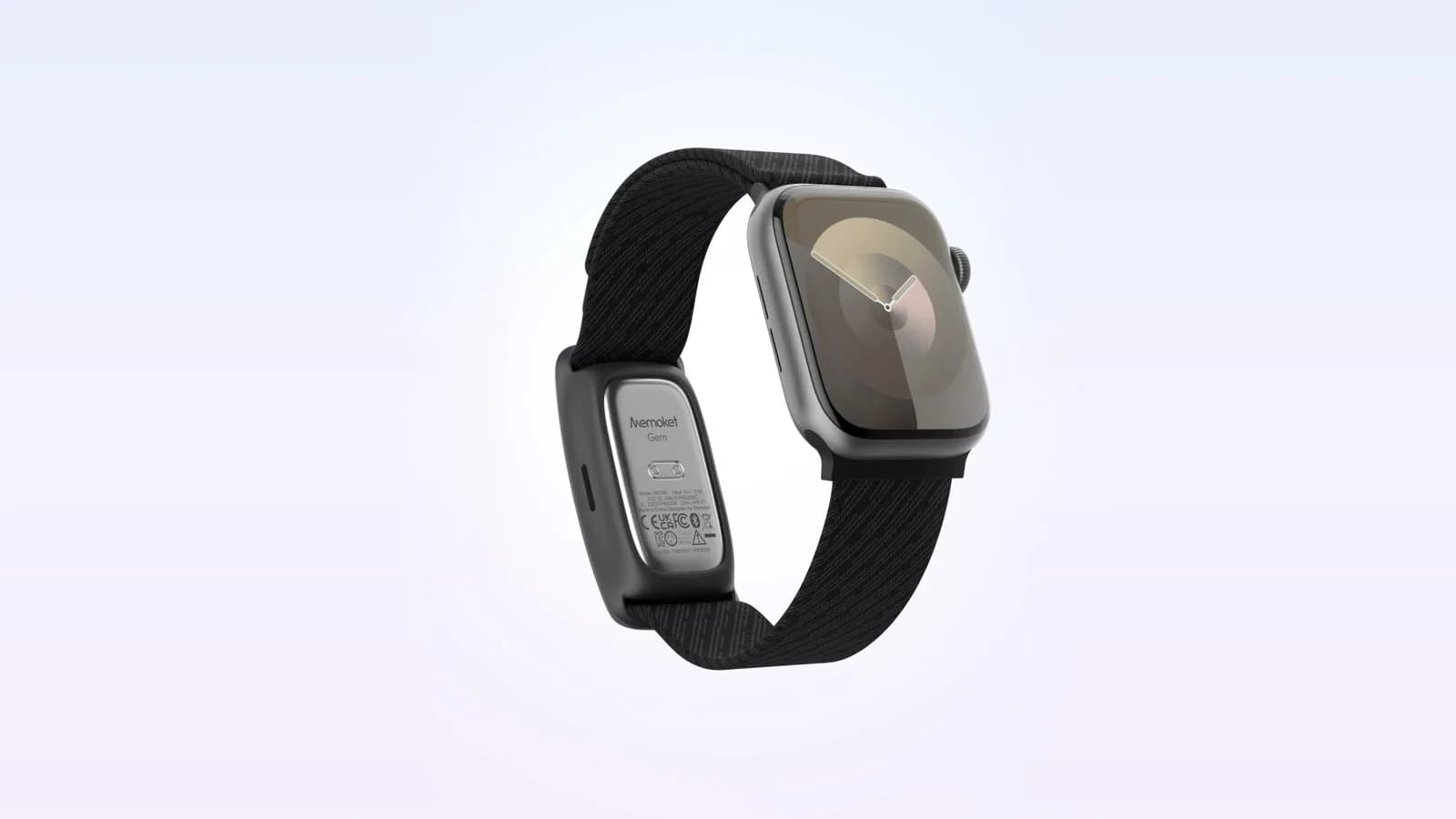 Memoket Gem AI note taker clipped into the black Apple Watch co-wear band next to a silver Apple Watch